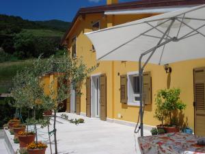 an umbrella in front of a yellow building at Secondo Monolocale Ovest in Dolcè