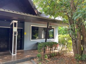 a house with a porch and a tree at Modern 2-Bedroom Villas with Pool Access in Krabi town