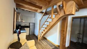 Una sala de estar con una escalera de madera en una casa pequeña. en Chalet Epilobe - Superbe duplex luxe, style refuge. MAE-5161, en Montgenèvre 8 fotos más