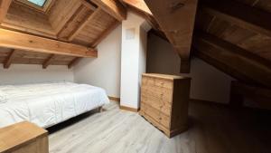 Un dormitorio con una cama y un techo de madera. en Chalet Epilobe - Superbe duplex luxe, style refuge. MAE-5161, en Montgenèvre