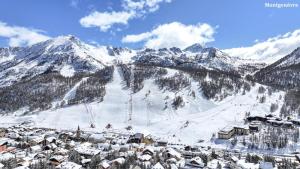 una estación de esquí en la nieve con una montaña en Chalet Epilobe - Superbe duplex luxe, style refuge. MAE-5161, en Montgenèvre