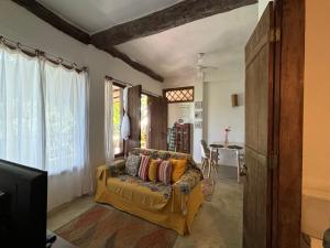 una sala de estar con un sofá y una mesa en Casinha romantica frente para o mar, en Ilhabela