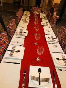 a long table with white plates and wine glasses at Mugabo in Kigali
