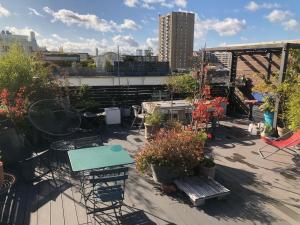 a rooftop patio with a table and chairs and plants at Superbe loft avec terrasse et jacuzzi aux Lilas près de Paris in Les Lilas