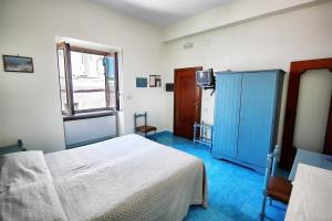 a bedroom with a white bed and a window at Hotel La Certosa in Massa Lubrense