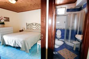 a bedroom with a bed and a sink and a toilet at Hotel La Certosa in Massa Lubrense