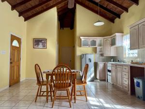 a kitchen with a table and chairs in a room at Cotton Heights Guest House in Nevis