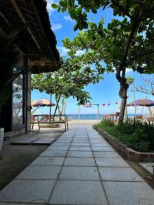 a walkway leading to the beach with umbrellas at Newlife Homestay in Dong Hoi