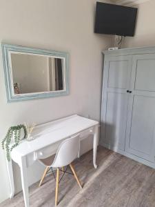 a white desk with a chair and a mirror at Lavender Lane Queenstown in Queenstown