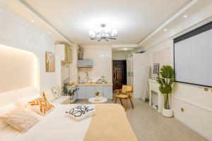 Una sala de estar con un sofá blanco y una cocina. en Xi'an Hills & Lostwine Boutique Retreat, en Xi'an