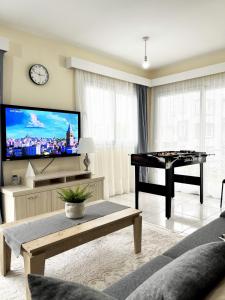 a living room with a ping pong table and a flat screen tv at VARIS Apartments 3BR in Kérynia