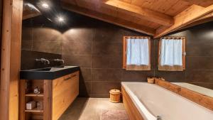 a bathroom with a bath tub and a sink at Large luxury chalet Megeve in Praz-sur-Arly +29 photos