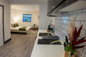 cocina con fregadero y dormitorio con cama en Ilkeston High End Apartments Perfect For Contractors, en Ilkeston