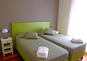a bedroom with two beds with towels on them at Appartamento Ideal in Sirmione