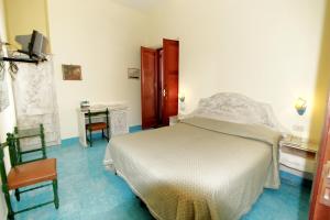 a bedroom with a bed and two chairs and a desk at Hotel La Certosa in Massa Lubrense