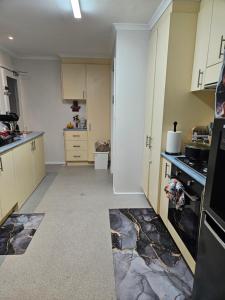 a kitchen with white cabinets and a black refrigerator at Cozy Escape in Sunbury