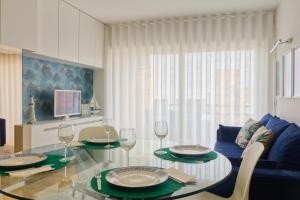 ein Wohnzimmer mit einem Glastisch und einem blauen Sofa in der Unterkunft Apartamento da Praia - Surf in Matosinhos