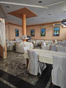 a banquet hall with white tables and white chairs at Hotel Millennium in Osijek