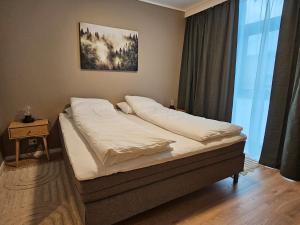 En eller flere senge i et værelse på Stor og ny leilighet med fjordutsikt