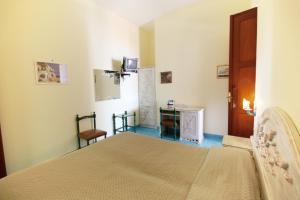 a bedroom with a bed and a table and a chair at Hotel La Certosa in Massa Lubrense