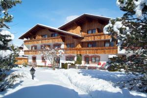 a large wooden house in the snow with snow covered trees at Gästehaus Haag in Ehrwald