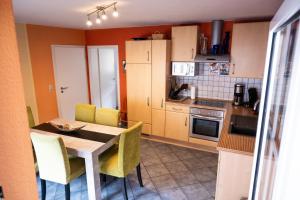 a kitchen with a table and yellow chairs in it at Fewo am Steinbrunnen in Brauneberg