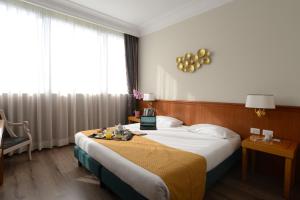 a hotel room with a bed with a tray of food on it at Hotel The Brand in Rome +53 photos