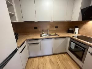 a small kitchen with white cabinets and a sink at Casa Valentini in Zapfendorf