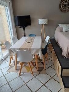 ein Esszimmer mit Tisch und Stühlen und einem Bett in der Unterkunft Studio bord de mer in Port-la-Nouvelle