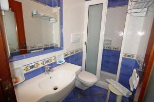 a blue and white bathroom with a toilet and a sink at Hotel La Certosa in Massa Lubrense