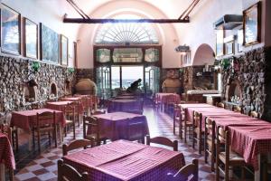 a restaurant with tables and chairs in a room at Hotel La Certosa in Massa Lubrense
