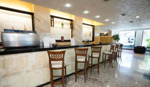 a bar with a row of chairs in a restaurant at Hotel Alexander Business and Conference in Abano Terme