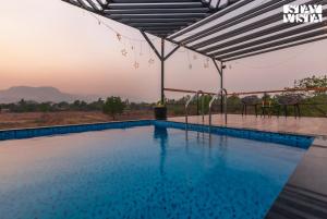 una piscina en un complejo con vistas en StayVista's One Villa - Pet-friendly charm with Farm views, Modern decor & A refreshing plunge pool, en Karjat