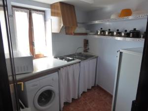 a kitchen with a sink and a washing machine at Casa Adelina in Morella