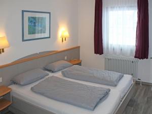 a bedroom with two beds and a window at Ferienhaus Nr 3, Kategorie Komfort, Feriendorf Hochbergle, Allgäu in Lechbruck