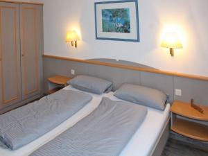two beds in a room with two tables and two lamps at Ferienhaus Nr 3, Kategorie Komfort, Feriendorf Hochbergle, Allgäu in Lechbruck