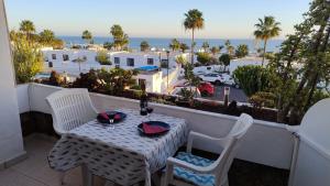 ein Tisch und Stühle auf einem Balkon mit Blick auf das Meer in der Unterkunft Vv Apartamento Gran Vista Los Marinos in Tías