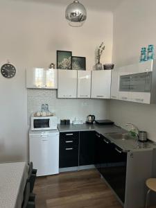 a kitchen with white cabinets and a white microwave at Pod Trzynastką in Sandomierz