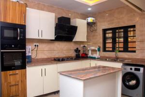 a kitchen with white cabinets and a counter top at Laribond's Place Magodo Lagos in Magodo