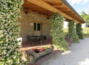 a patio with a table and a bunch of flowers at Casale delle Lucrezie by VacaVilla in Due Santi