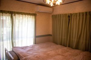 a bedroom with a bed and a window with curtains at ゲストハウスＡ＆C in Kameoka +23 photos