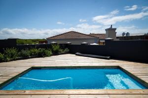 a small blue swimming pool on a wooden deck at SandDollar - Entire house in Cape St Francis