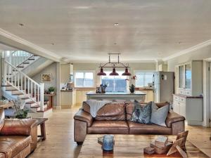 a living room with a couch and a kitchen at SandDollar - Entire house in Cape St Francis