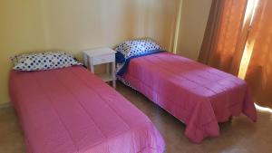 dos camas sentadas una al lado de la otra en una habitación en Apartamentos Los Teros en San José