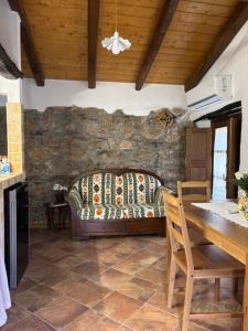 a living room with a table and a stone wall at Osini Ecciu Home in Osini