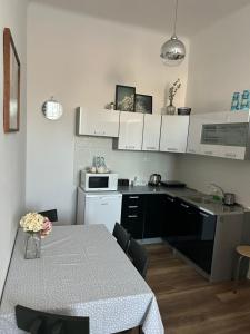 a kitchen with a table and a kitchen with white cabinets at Pod Trzynastką in Sandomierz