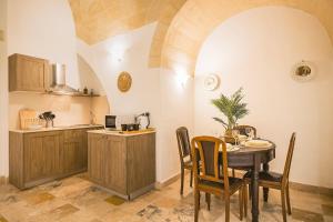 a kitchen and dining room with a table and chairs at Sassi Suite - Elegant Historic Home in Matera