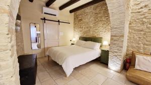 a bedroom with a white bed and a stone wall at CASA OCRA in Vasto