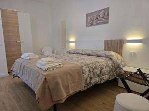 una camera d'albergo con un letto con asciugamani sopra di Athena ad Alghero