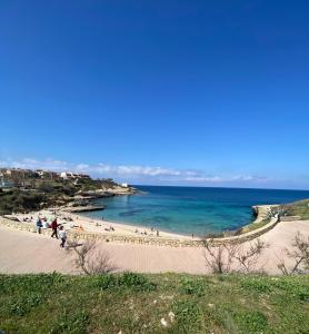 ポルト・トッレスにあるMonCici Houseの砂浜と水上の人々のいる浜